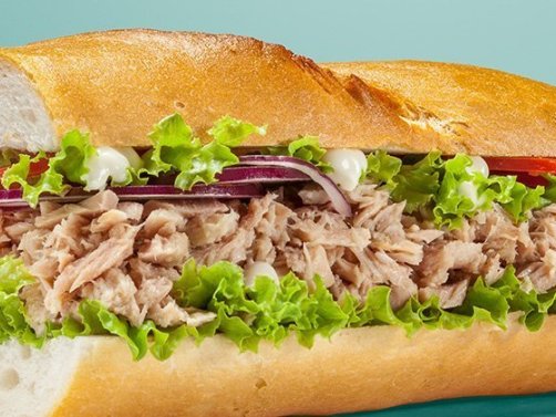 Ein Thunfisch-Croque mit Salat, Zwiebeln und Tomate