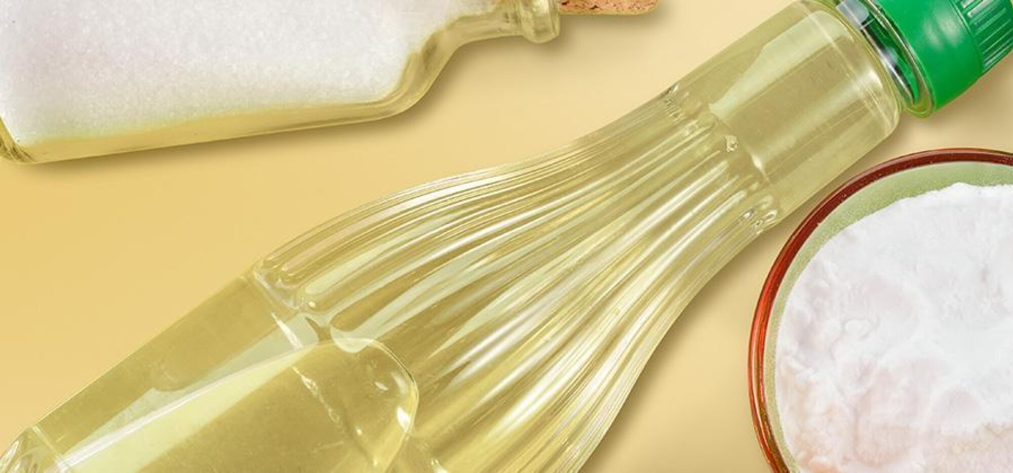 Eine Flasche Essig und eine kleine Schale mit weißem Pulver